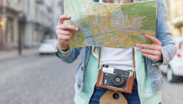 Mid Section Female Traveler With Camera Holding Map Hand (1)
