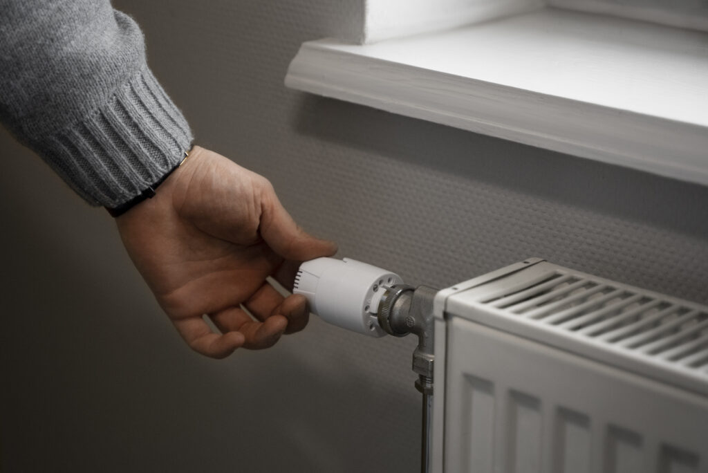 Man Turning Off Radiator Energy Crisis