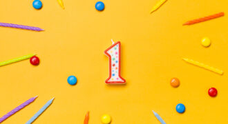 Red Number One Candle Surrounded With Colorful Candles Gems Yellow Backdrop