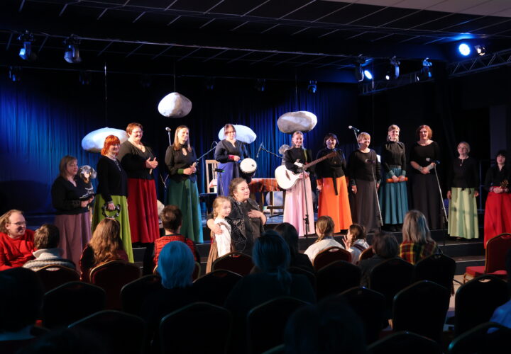 Stāstnieku festivāla Ziv zup koncertā Cik augšā sīku zvaigžņu, zemē sīku akmentiņu dalībnieki vienojas tautasdziesmā Upe nesa ozoliņu. Uz skatuves – Padures ansamblis Harmonija, centrā festivāla rīkotāja Ina Celitāne un mazā stāstniece Gerda Gruze.